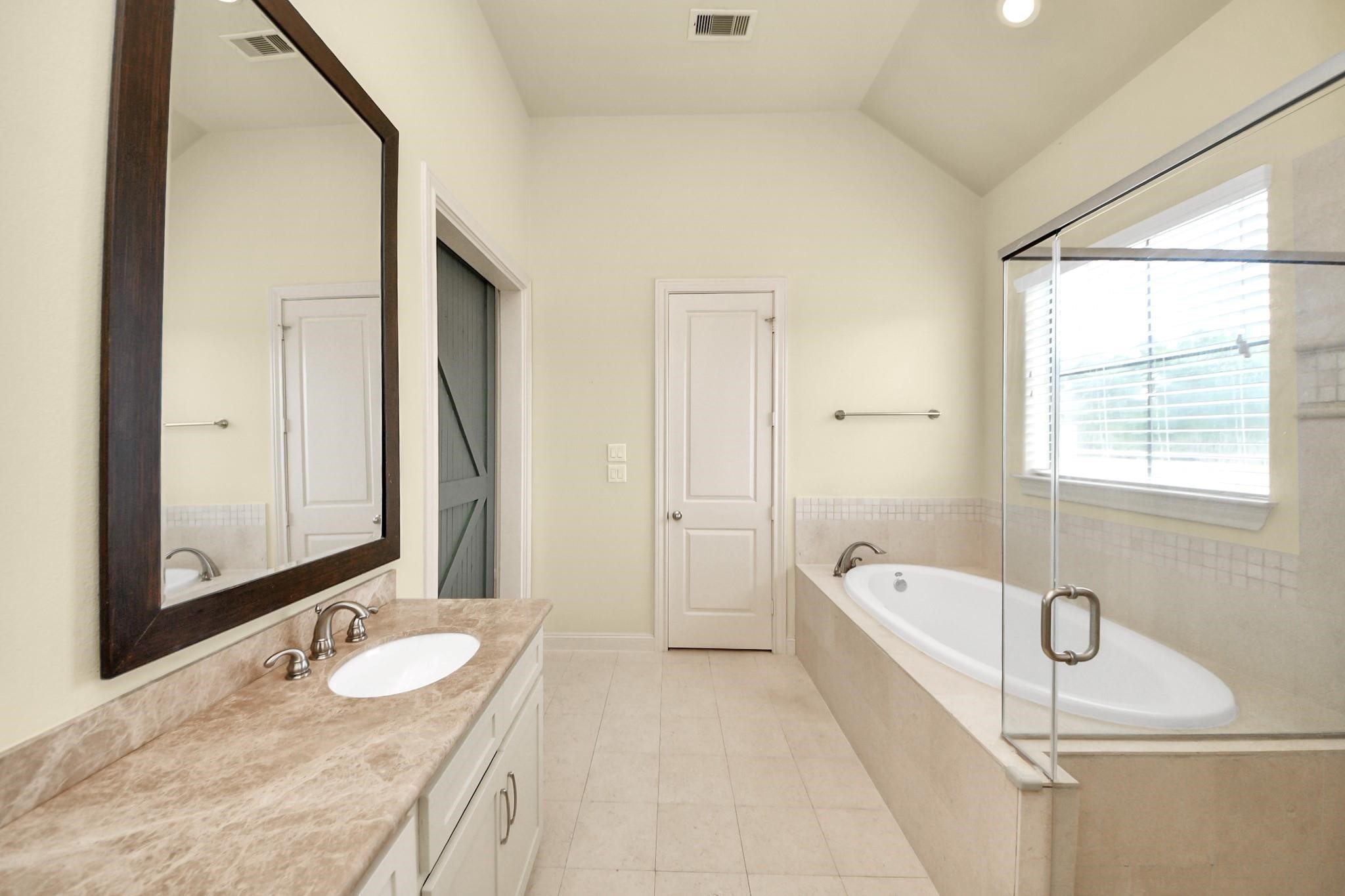 5617 Kiam Street, Unit A Houston, TX 77007 - Photo 32 of 46 a bathroom with a granite countertop tub sink and mirror