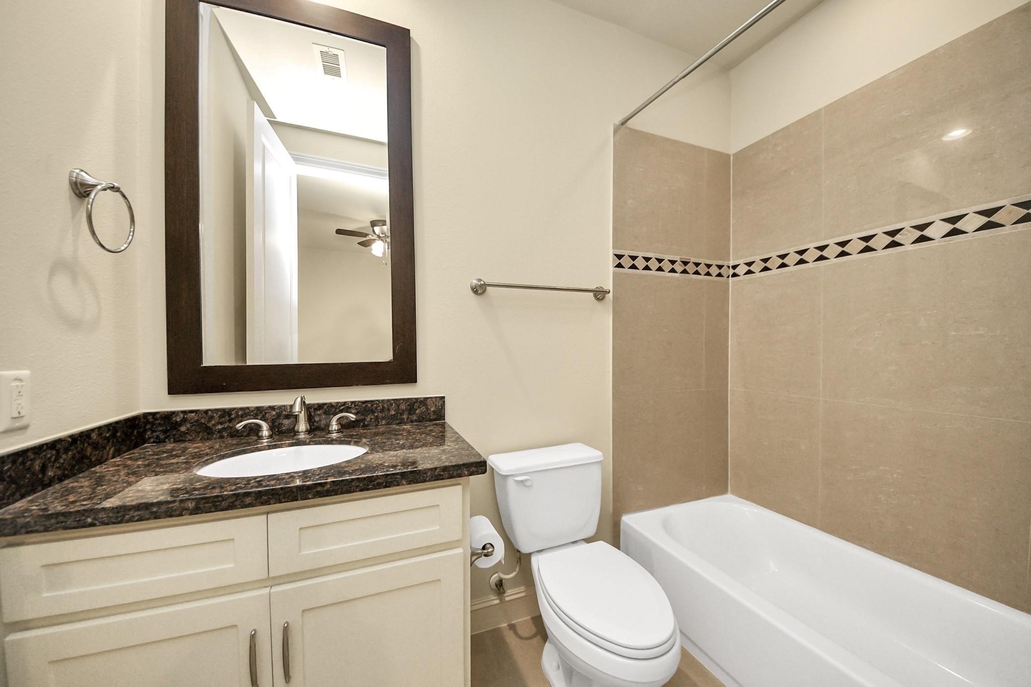 5617 Kiam Street, Unit A Houston, TX 77007 - Photo 8 of 46 a bathroom with a granite countertop sink mirror vanity and toilet
