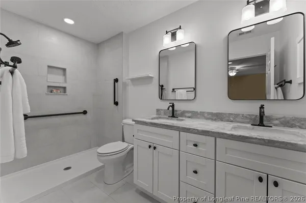 a bathroom with a granite countertop toilet sink and mirror