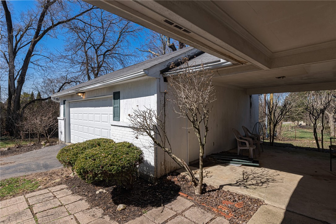 6885 Garber Road Clayton, OH 45415 - Photo 20 of 24 This property features a practical attached carport and a functional garage, perfect for parking and storage.