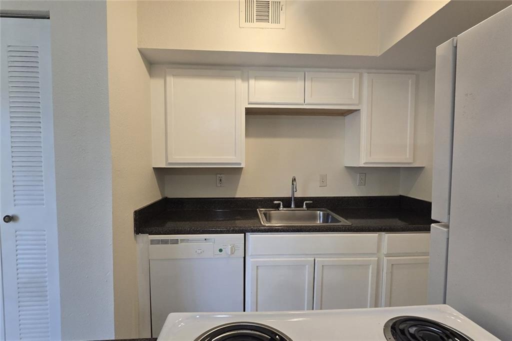 1418 Foxhall Lane Southeast, Unit 8 Atlanta, GA 30316 - Photo 22 of 50 a kitchen with granite countertop white cabinets and black appliances