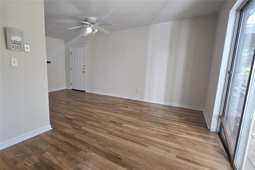 1418 Foxhall Lane Southeast, Unit 8 Atlanta, GA 30316 - Photo 7 of 41 a view of an empty room with wooden floor and a chandelier fan