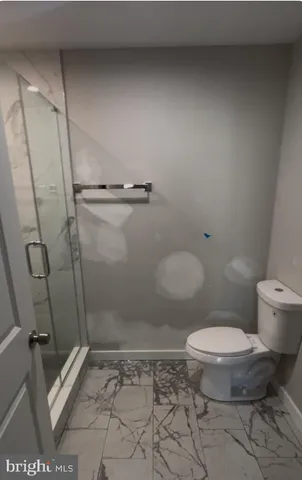 a bathroom with a toilet and a shower