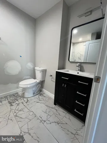 a bathroom with a sink a toilet and mirror