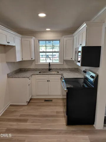 a kitchen with stainless steel appliances granite countertop a stove a sink and a microwave