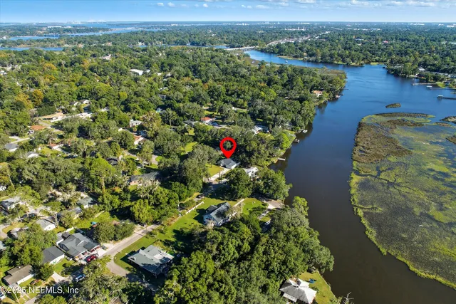 an aerial view of residential houses with outdoor space and trees