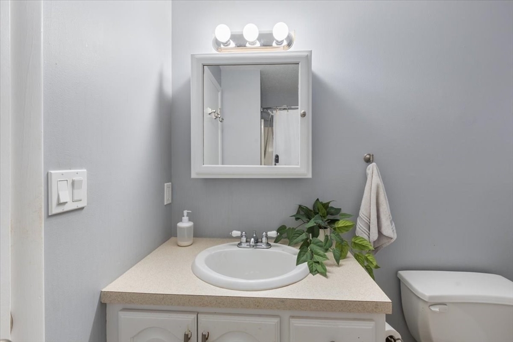 36 Dunham Road, Unit 302 Beverly, MA 01915 - Photo 19 of 21 a bathroom with a sink a toilet and mirror