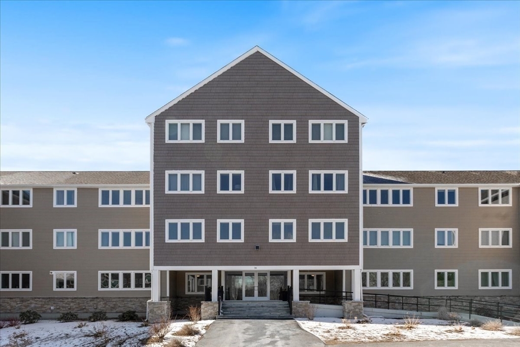 36 Dunham Road, Unit 302 Beverly, MA 01915 - Photo 20 of 21 a front view of a building with lot of cars and trees