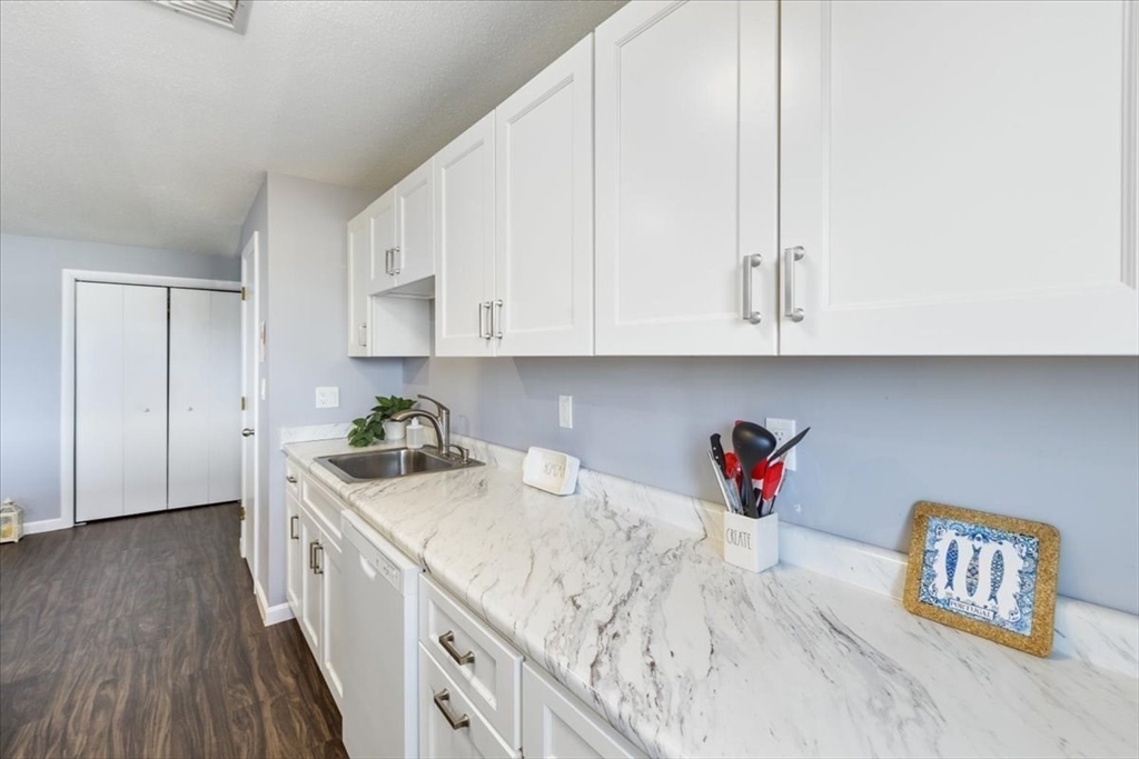 36 Dunham Road, Unit 302 Beverly, MA 01915 - Photo 2 of 21 a kitchen with granite countertop white cabinets and sink