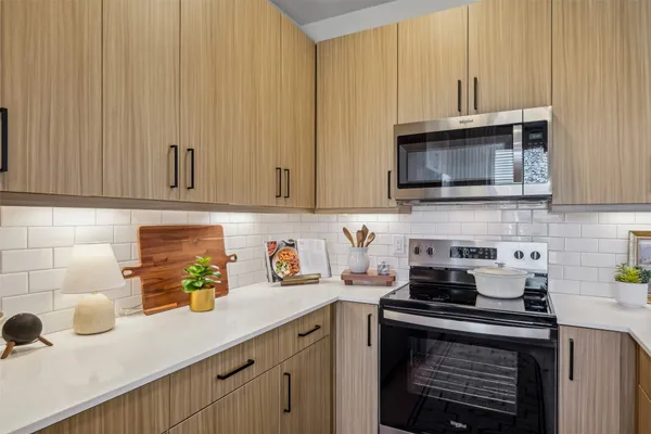 a kitchen with stainless steel appliances granite countertop a sink a stove and a microwave