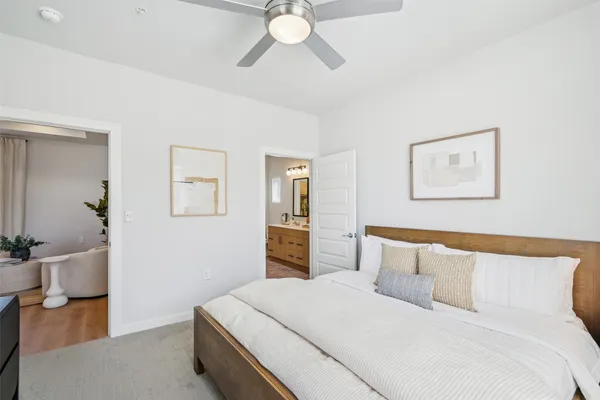 a bedroom with a large bed and a chandelier