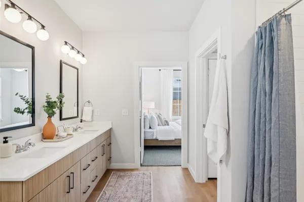 a en suite bathroom with a double vanity sink a mirror and shower