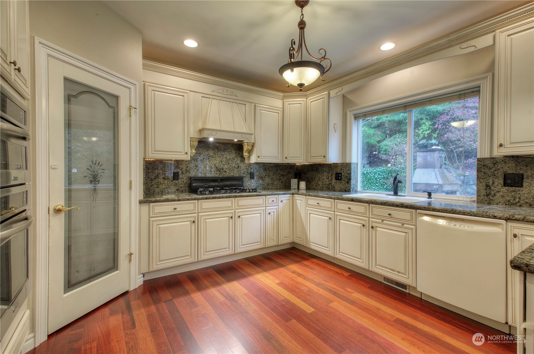 1013 R Street Northwest Auburn, WA 98001 - Photo 8 of 31 a kitchen with stainless steel appliances granite countertop a stove a sink and white cabinets with wooden floors