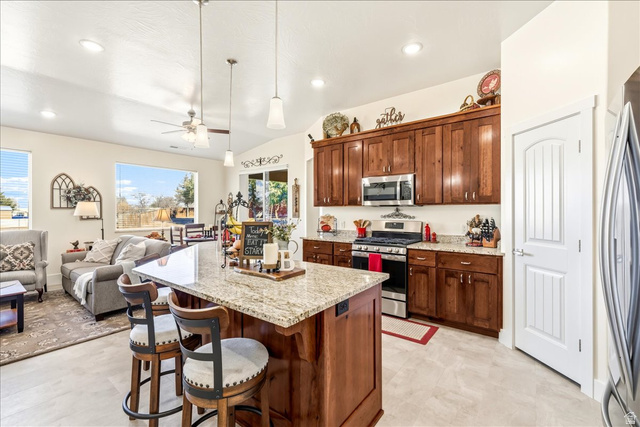 357 East Main Street Enterprise, UT 84725 - Photo 70 of 71 Kitchen featuring a breakfast bar, stainless steel appliances, open floor plan, light stone counters, and ceiling fan