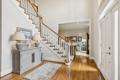 a view of a hallway with wooden floor and staircase