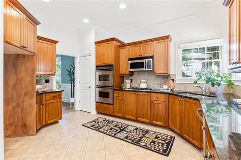 a kitchen with stainless steel appliances granite countertop a refrigerator stove and sink
