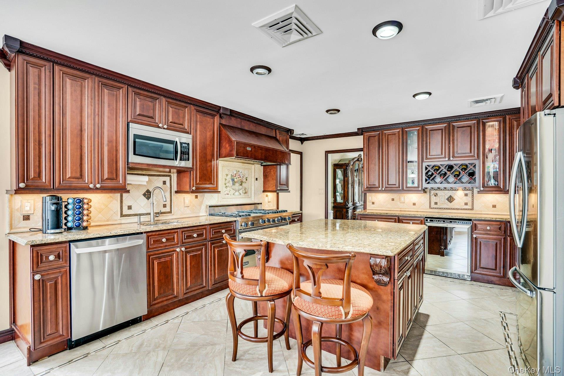 41 Hearthstone Drive Dix Hills, NY 11746 - Photo 20 of 50 a kitchen with stainless steel appliances kitchen island granite countertop a table chairs sink and cabinets
