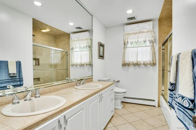 a bathroom with a granite countertop sink mirror and a bathtub
