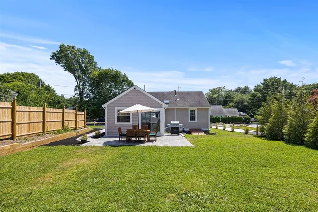 a view of a house with a big yard and potted plants