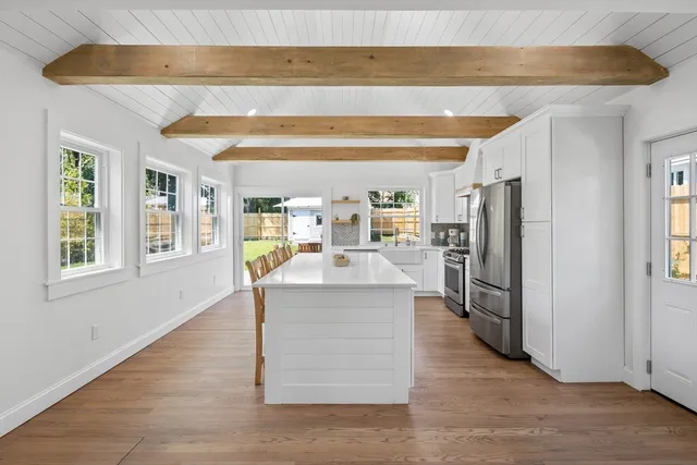 a kitchen with stainless steel appliances granite countertop a refrigerator a stove and a wooden floors