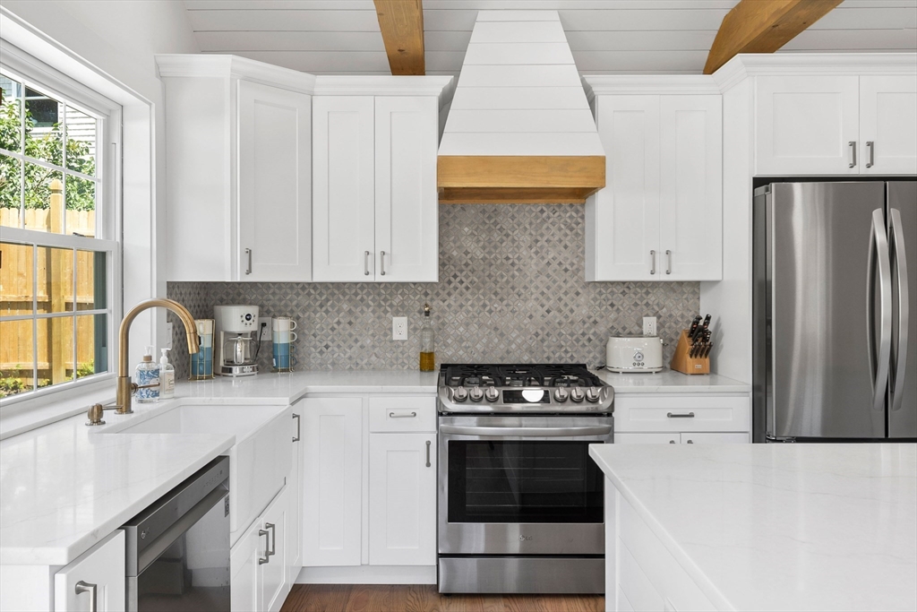 6 Stenbeck Place Scituate, MA 02066 - Photo 7 of 24 a kitchen with stainless steel appliances a stove a sink a refrigerator white cabinets and a window