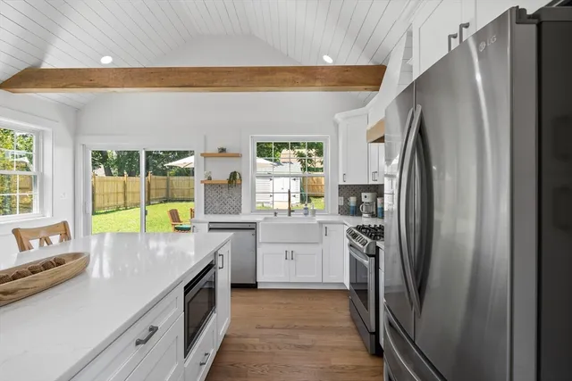 a kitchen with a sink a refrigerator and a stove top oven