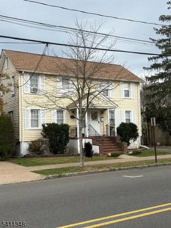a view of a white house with a street