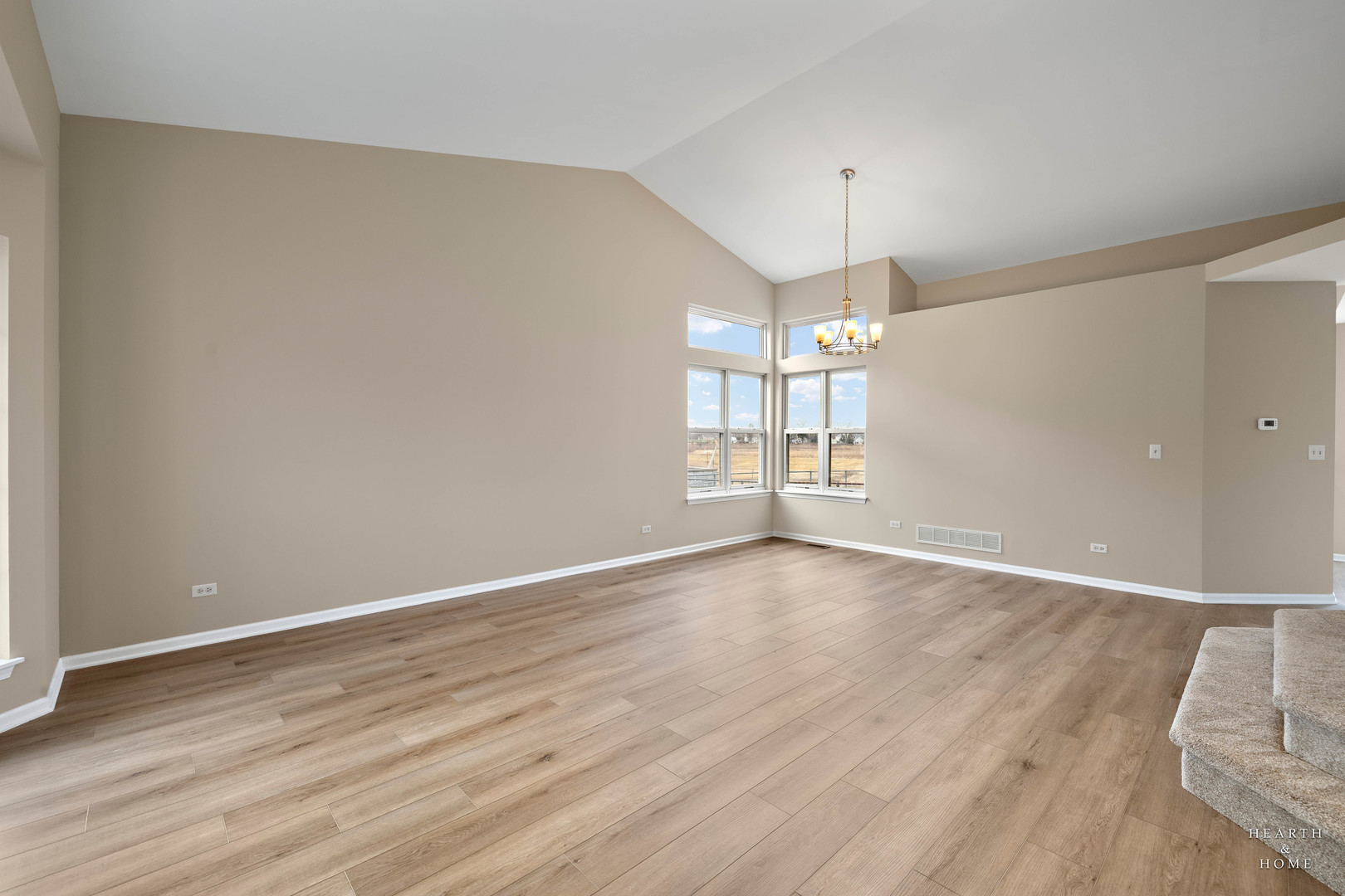 305 Harvest Gate Road Lake In The Hills, IL 60156 - Photo 15 of 36 an empty room with wooden floor chandelier and windows