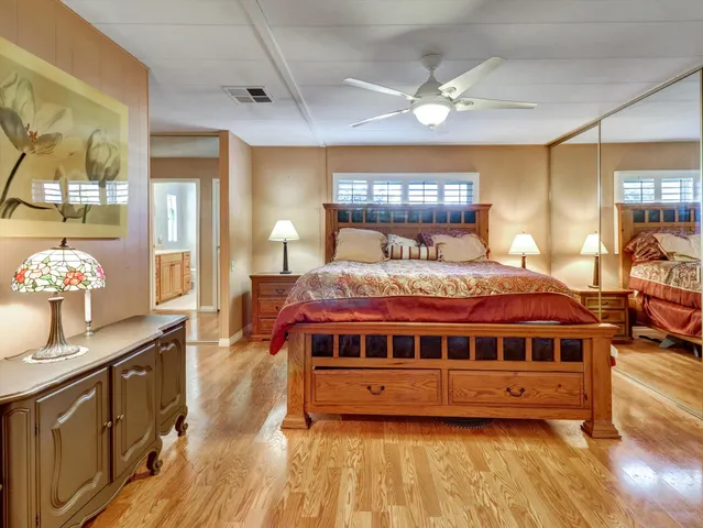 a view of a bedroom with a bed and wooden floor