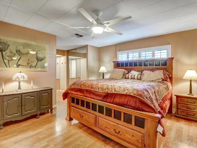 a bedroom with a large bed a chandelier and dresser