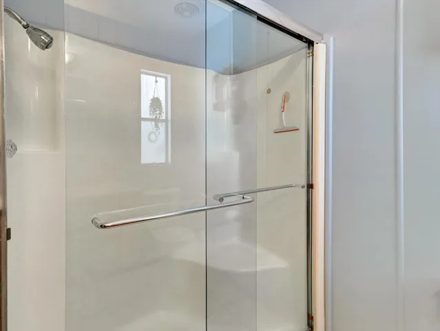 a bathroom with a glass shower door and a shower