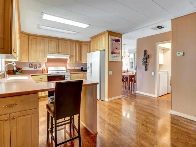 a kitchen with a table chairs refrigerator and a sink