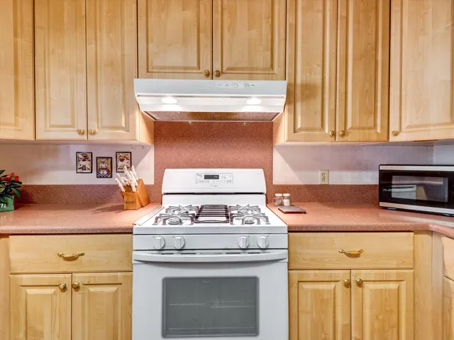 a kitchen with stove top oven and cabinets
