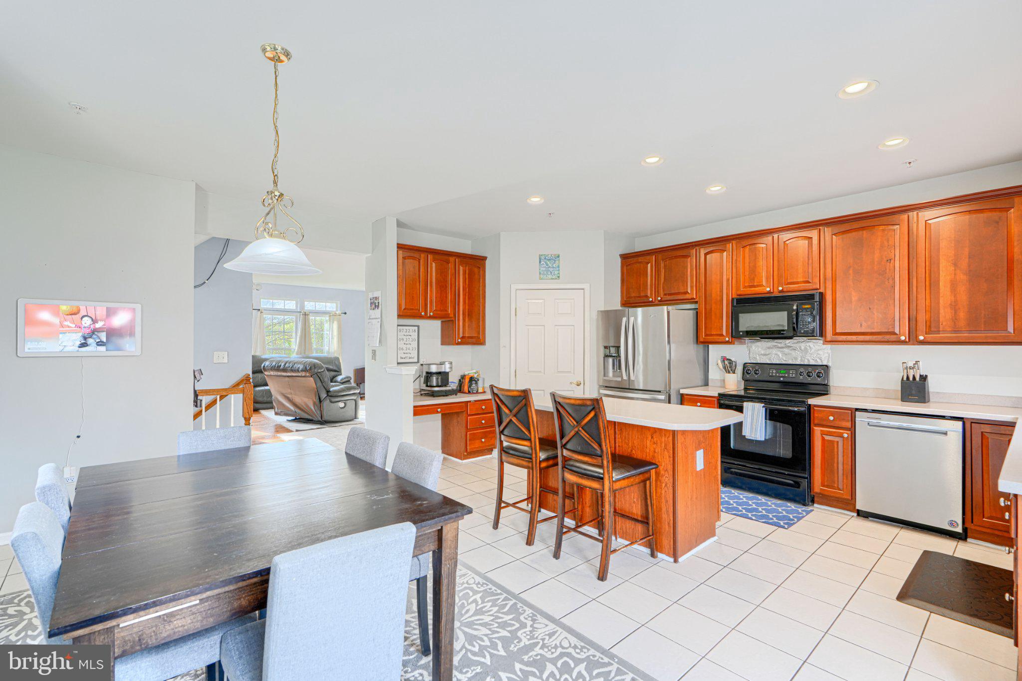 9307 Summit View Way Perry Hall, MD 21128 - Photo 6 of 26 a kitchen with stainless steel appliances granite countertop a stove top oven a sink dishwasher and a living room with furniture