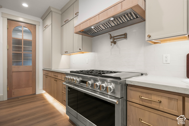 1175 North Elk Rdg Lane, Unit 201 Alpine, UT 84004 - Photo 15 of 38 Stainless steel range, wood-finish flooring, white subway tile backsplash, light-toned upper cabinetry, and natural wood lower cabinetry
