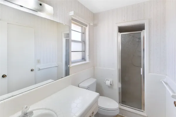 a bathroom with a sink a toilet and shower