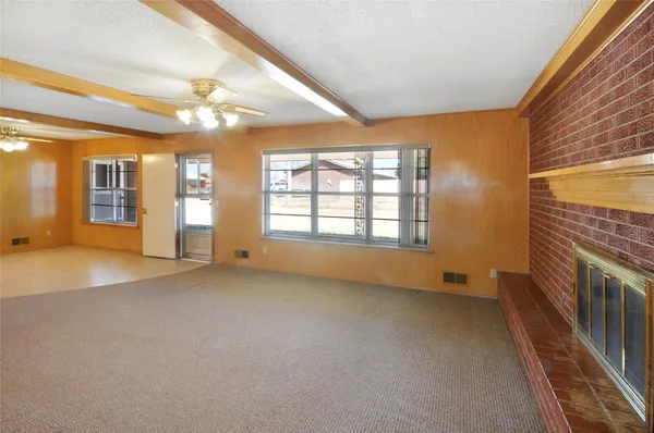 a view of an empty room with a fireplace and a window
