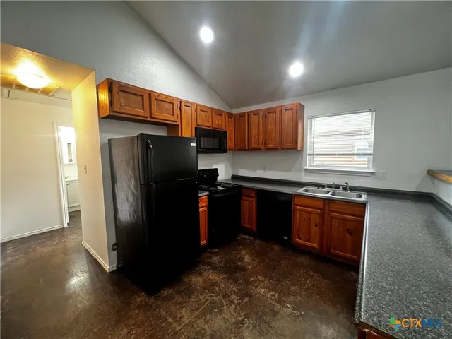 a kitchen with stainless steel appliances granite countertop a refrigerator and a sink