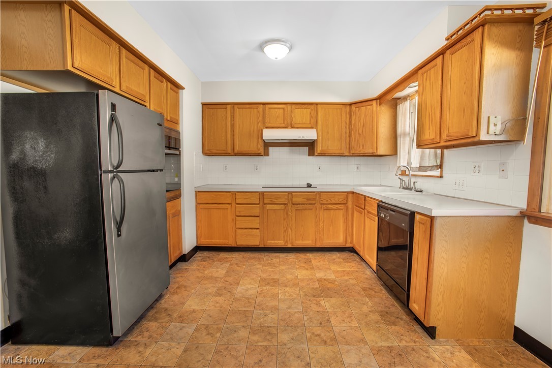 1590 Norledge Road Akron, OH 44305 - Photo 13 of 21 Kitchen featuring light tile floors, sink, stainless steel appliances, and backsplash