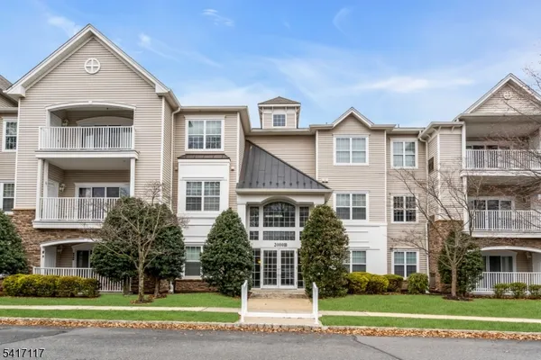a view of a big house with a yard and large trees