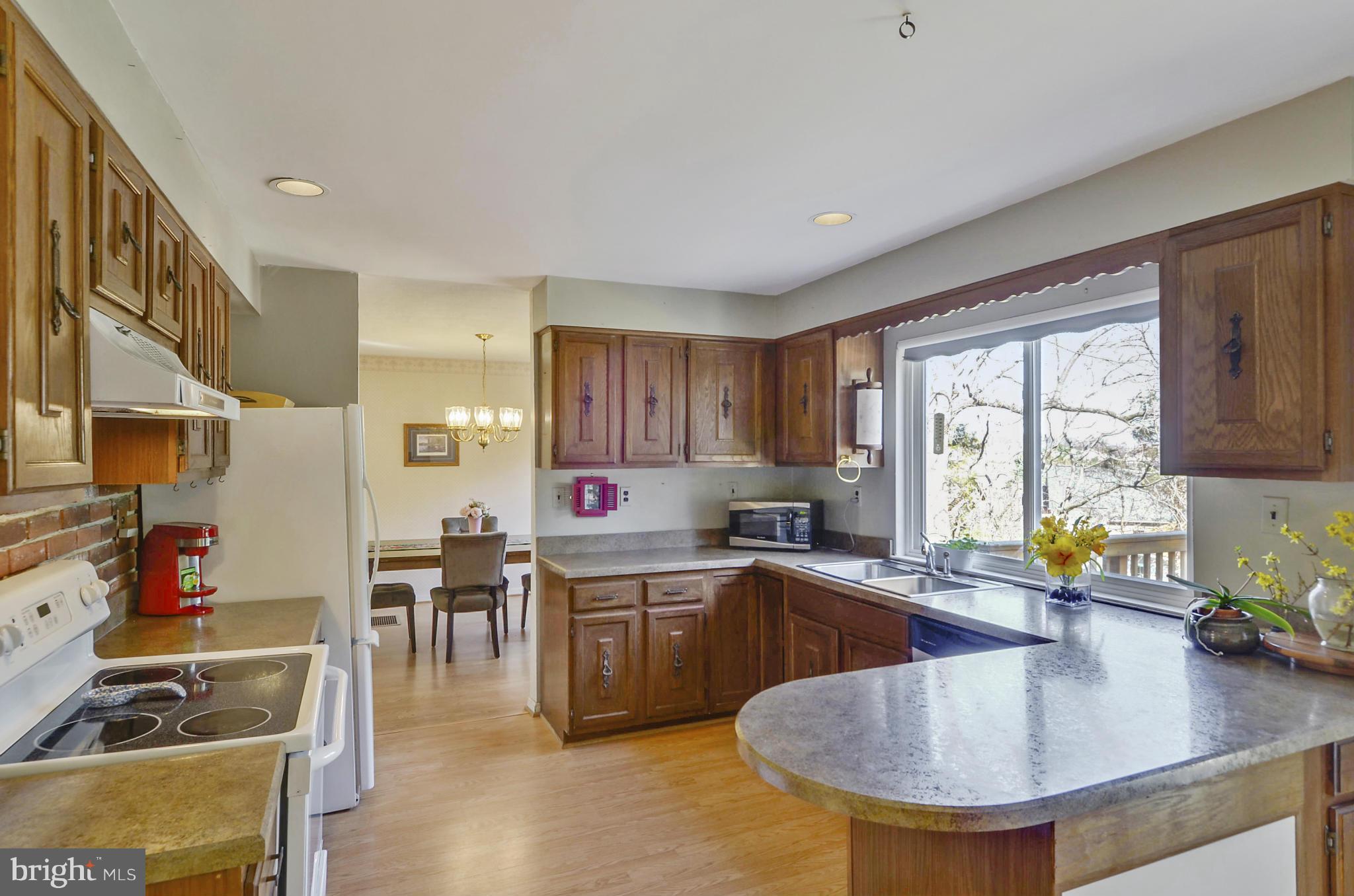 9833 Moyer Road Damascus, MD 20872 - Photo 7 of 26 a kitchen with stainless steel appliances granite countertop a sink a stove and a refrigerator