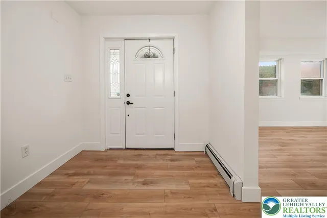 a bathroom with a toilet a sink and wooden floor