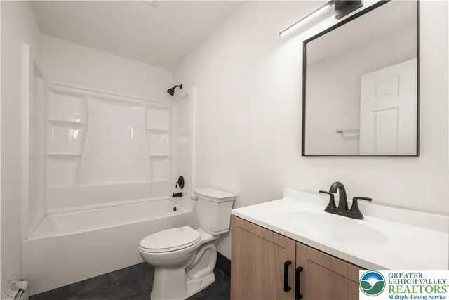 a living room with furniture a flat screen tv and a potted plant