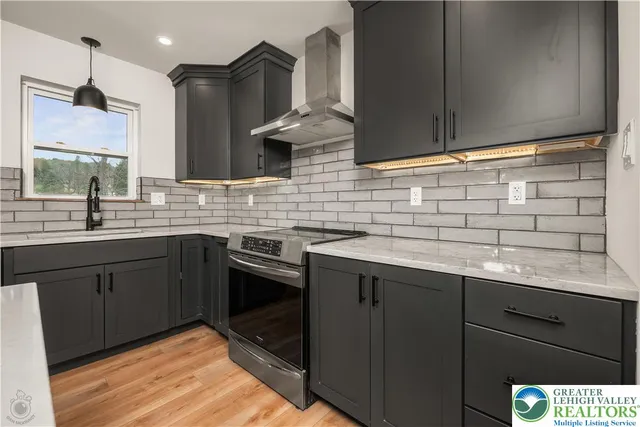 a kitchen with stainless steel appliances granite countertop a sink stove and microwave