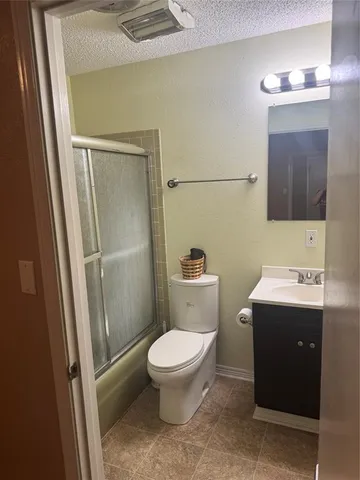 a bathroom with a granite countertop sink a toilet and a mirror