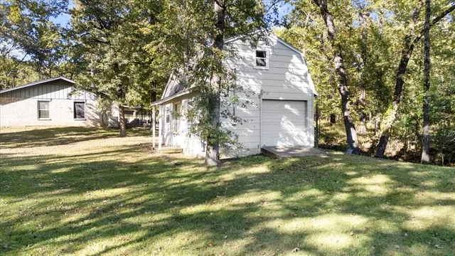 a view of a house with a big yard and large trees