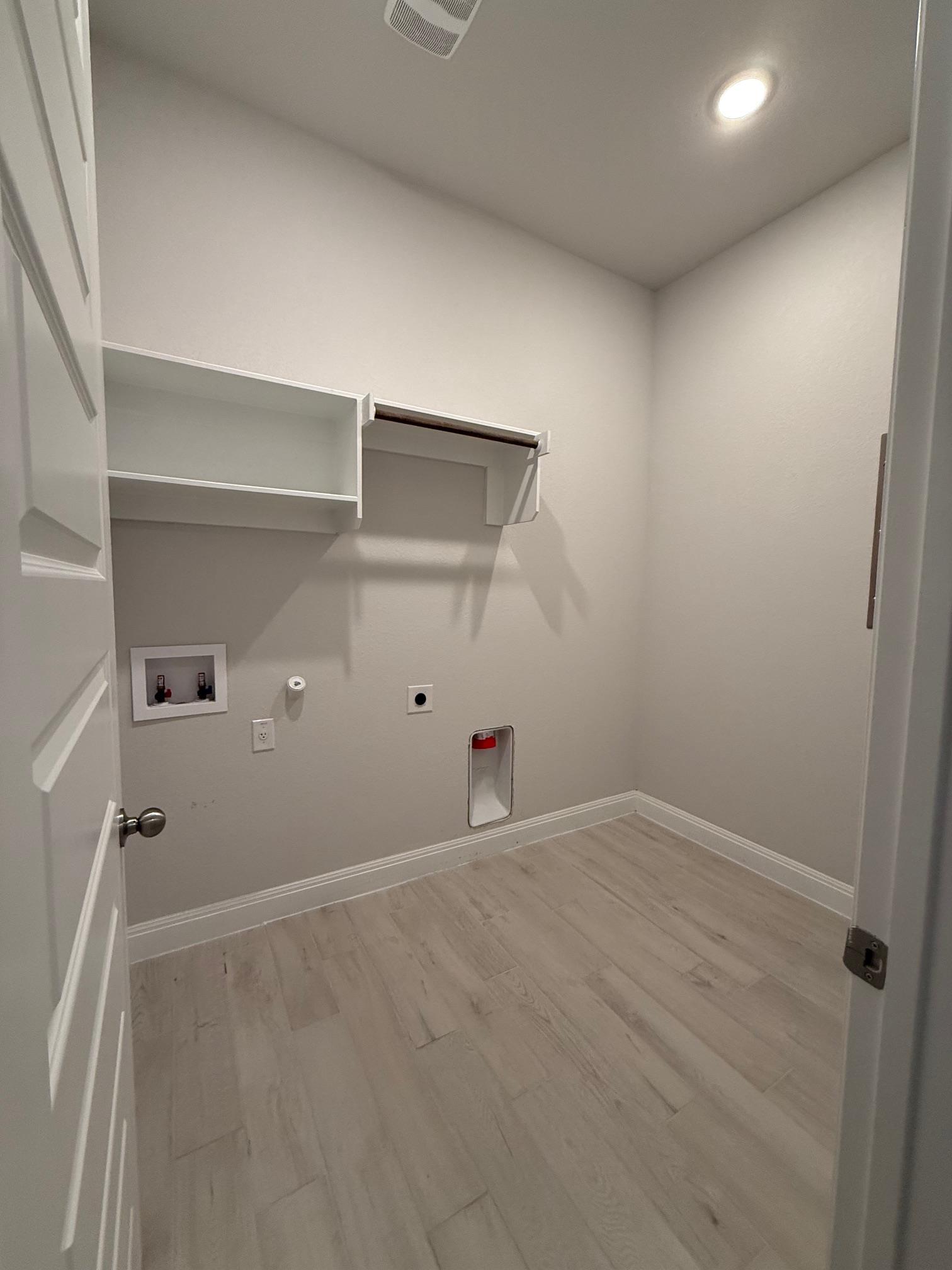 1432 Ridge Runner Drive Georgetown, TX 78628 - Photo 24 of 27 Laundry room featuring gas dryer hookup, light wood-type flooring, hookup for an electric dryer, hookup for a washing machine, and recessed lighting