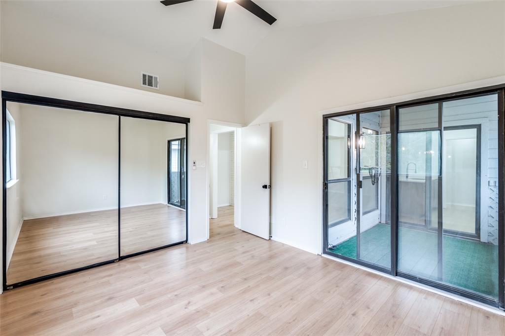 17490 Meandering Way, Unit 2202 Dallas, TX 75252 - Photo 21 of 24 Vaulted ceiling with an overhead fan, wood-finish flooring, mirrored sliding closet doors, and sliding glass doors to an outdoor area
