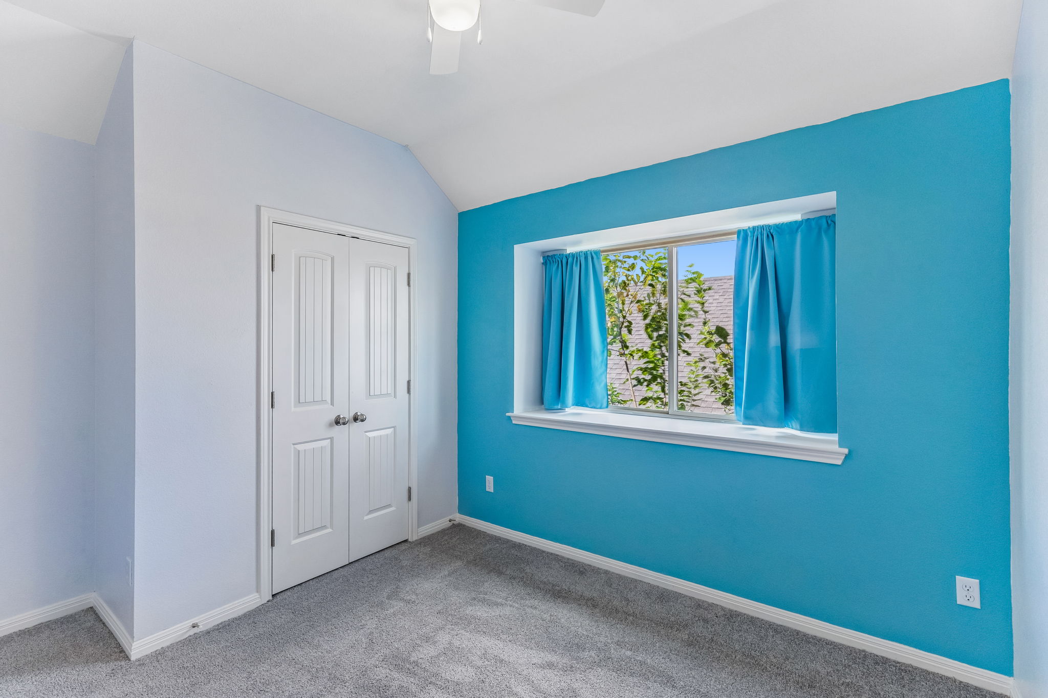 689 Nautical Loop Kyle, TX 78640 - Photo 24 of 34 A well-lit bedroom features plush carpeting and a vibrant accent wall with a bright window.