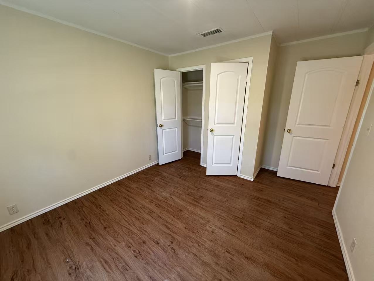 23393 Nameless Road, Unit 113 Leander, TX 78641 - Photo 16 of 16 Unfurnished bedroom featuring ornamental molding, dark wood finished floors, and a closet